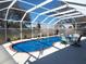 Enclosed pool area featuring a covered pool with a blue tarp and outdoor seating at 17070 Se 93Rd Tellfier Ter, The Villages, FL 32162