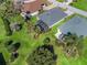 Aerial view of a home featuring lush landscaping, screened lanai, and well-maintained lawn in a serene neighborhood at 17504 Se 119Th Cir, Summerfield, FL 34491