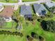Aerial view of a property showcasing lush landscaping, screened lanai, and a well-kept lawn within a peaceful community at 17504 Se 119Th Cir, Summerfield, FL 34491