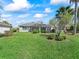 Lush backyard with well-maintained landscaping and a screened-in lanai, ideal for enjoying the outdoors in comfort at 17504 Se 119Th Cir, Summerfield, FL 34491