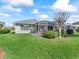 Spacious backyard featuring a screened-in lanai and lush green lawn, perfect for outdoor living and entertaining at 17504 Se 119Th Cir, Summerfield, FL 34491