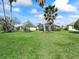 Expansive backyard featuring lush green lawn, mature palm trees, and a screened-in lanai for outdoor enjoyment at 17504 Se 119Th Cir, Summerfield, FL 34491