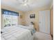 Bright bedroom featuring a comfortable bed, white door and a large window with backyard views at 17504 Se 119Th Cir, Summerfield, FL 34491