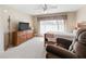Cozy bedroom with a ceiling fan, window with blinds, and a comfortable chair at 17504 Se 119Th Cir, Summerfield, FL 34491