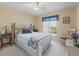 Cozy bedroom featuring a brass bed frame, neutral walls, and bright natural light from the window at 17504 Se 119Th Cir, Summerfield, FL 34491