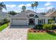 Inviting home featuring a well-manicured lawn, brick driveway, and nicely landscaped garden beds adding curb appeal at 17504 Se 119Th Cir, Summerfield, FL 34491