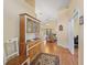 Inviting hallway with wood floors, decorative cabinet, and views into the living spaces at 17504 Se 119Th Cir, Summerfield, FL 34491