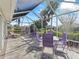 Screened lanai offers a relaxing outdoor space with stylish purple patio furniture and view of lush landscaping at 17504 Se 119Th Cir, Summerfield, FL 34491