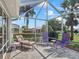 Relaxing screened lanai featuring comfortable outdoor seating and a view of the beautifully landscaped backyard at 17504 Se 119Th Cir, Summerfield, FL 34491