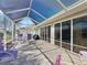 Spacious screened lanai with paved flooring, outdoor seating, and a convenient grill for outdoor entertainment at 17504 Se 119Th Cir, Summerfield, FL 34491