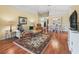 Cozy living room boasts hardwood floors, area rug, rocking chair, and adjoining dining area at 17504 Se 119Th Cir, Summerfield, FL 34491
