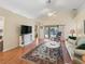 Bright living room with wood floors, vaulted ceilings, a ceiling fan, and access to the backyard at 17504 Se 119Th Cir, Summerfield, FL 34491