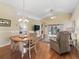 Open-concept living room with wood floors, vaulted ceilings, a ceiling fan, and access to the outdoor living spaces at 17504 Se 119Th Cir, Summerfield, FL 34491