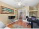 Well-lit office space with wood floors and a ceiling fan, perfect for working from home at 17504 Se 119Th Cir, Summerfield, FL 34491