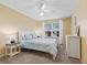 Comfortable bedroom with blue bedding, a ceiling fan, and a window with natural light at 1904 Augustine Dr, The Villages, FL 32159