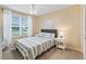 Bright bedroom features a large window, ceiling fan and a comfortable queen-sized bed at 1904 Augustine Dr, The Villages, FL 32159