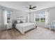 Bright bedroom with neutral tones, carpet, ceiling fan, and natural light from two large windows at 1904 Augustine Dr, The Villages, FL 32159