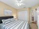 Cozy bedroom featuring gray and white bedding and a closet at 1904 Augustine Dr, The Villages, FL 32159