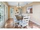 Cozy dining room featuring wood floors, white chairs, and French doors leading to the outside at 1904 Augustine Dr, The Villages, FL 32159