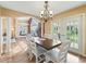 Sunlit dining room with wood floors, white chairs, and an archway leading to the living room at 1904 Augustine Dr, The Villages, FL 32159