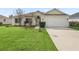 Charming single-story home with lush lawn, well-manicured landscaping, and a two-car garage at 1904 Augustine Dr, The Villages, FL 32159