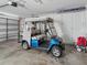 Spacious garage with storage and a stylish blue Yamaha golf cart at 1904 Augustine Dr, The Villages, FL 32159