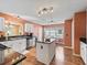 Open kitchen with stainless steel appliances, hardwood floors, an island, and adjacent breakfast area at 1904 Augustine Dr, The Villages, FL 32159