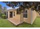 Back patio featuring mature trees and a screened in porch at 1938 Sassparilla Way, The Villages, FL 32162