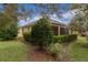 Lush backyard featuring mature trees, manicured hedges and a screened in porch at 1938 Sassparilla Way, The Villages, FL 32162