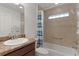 A standard bathroom features a tiled shower and tub with a sink and vanity at 1938 Sassparilla Way, The Villages, FL 32162