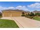 Spacious home with a large driveway leading to an attached two-car garage at 1938 Sassparilla Way, The Villages, FL 32162