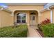 Inviting front porch features a cozy seating area and mature landscaping at 1938 Sassparilla Way, The Villages, FL 32162