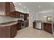 A beautifully appointed kitchen features stainless appliances and rich cabinetry with ample counter space at 1938 Sassparilla Way, The Villages, FL 32162