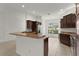 A kitchen offers stainless appliances, rich cabinetry, and a tiled floor, ideal for cooking at 1938 Sassparilla Way, The Villages, FL 32162