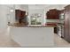 Open-concept kitchen with rich dark cabinetry, modern stainless appliances, and granite countertops at 1938 Sassparilla Way, The Villages, FL 32162