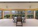 A bright and inviting screened-in patio features a ceiling fan and a table with seating at 1938 Sassparilla Way, The Villages, FL 32162
