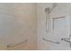 Shower featuring a handheld shower head, grab bars, and tiled walls at 1938 Sassparilla Way, The Villages, FL 32162