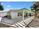 A backyard features a covered patio, manicured landscaping, and an area for seating at 1952 Peachtree Ave, The Villages, FL 32162