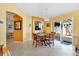 Cozy dining room with tile floors, bright yellow walls, and access to an outdoor patio at 1952 Peachtree Ave, The Villages, FL 32162