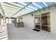 A covered patio features sliding glass doors, a concrete floor, and an outdoor dining set at 1952 Peachtree Ave, The Villages, FL 32162