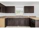 Close-up of the kitchen featuring dark wood cabinets, tile flooring, and granite countertops at 209 Orange Ave, Fort Meade, FL 33841