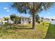 Well-maintained backyard featuring a screened lanai and mature landscaping creating a private outdoor space at 2116 Baldwin Run, The Villages, FL 32162