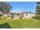 Private backyard features lush green lawn and well manicured landscaping at 2116 Baldwin Run, The Villages, FL 32162