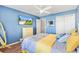 Spacious bedroom with blue walls, ceiling fan, wood floors, and a flat screen television at 2116 Baldwin Run, The Villages, FL 32162