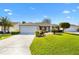 Charming single-story home featuring a well-manicured lawn and concrete driveway leading to the attached garage at 2116 Baldwin Run, The Villages, FL 32162