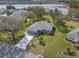 Beautiful aerial view of a single-story home with a well-manicured lawn near a lake at 21902 King Henry Ave, Leesburg, FL 34748