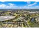 Expansive aerial view showcasing a golf course, community amenities, and surrounding lakes under a blue, cloudy sky at 21902 King Henry Ave, Leesburg, FL 34748