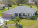 Spacious single-story home with a manicured lawn, beautiful landscaping, and mature palm trees on an expansive lot at 21902 King Henry Ave, Leesburg, FL 34748