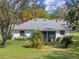 Backyard featuring a manicured lawn, landscaping and mature trees at 21902 King Henry Ave, Leesburg, FL 34748