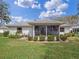 The back of the house with a screened in porch, and landscaped yard at 21902 King Henry Ave, Leesburg, FL 34748